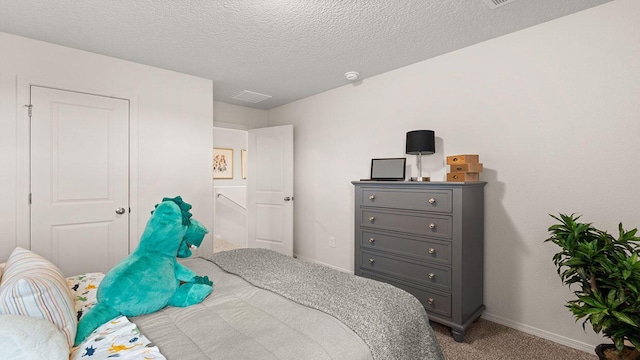 carpeted bedroom with baseboards and a textured ceiling