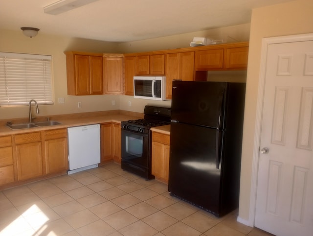 kitchen with light countertops, a sink, black appliances, and light tile patterned floors