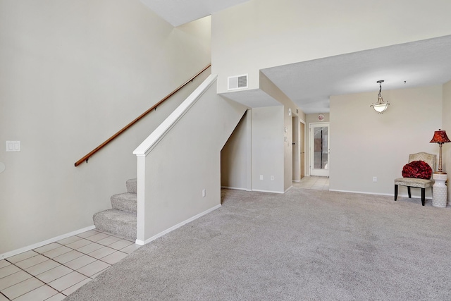 unfurnished living room featuring baseboards, stairs, visible vents, and light colored carpet