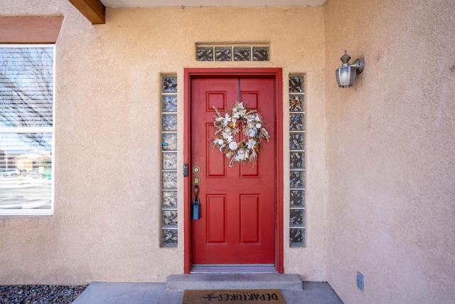 view of exterior entry with stucco siding