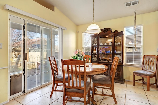 dining area with lofted ceiling, visible vents, plenty of natural light, and light tile patterned flooring