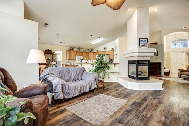 living area with a wealth of natural light, a fireplace, wood finished floors, and visible vents