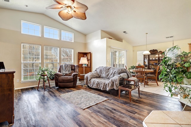 living area with lofted ceiling, visible vents, ceiling fan, and wood finished floors