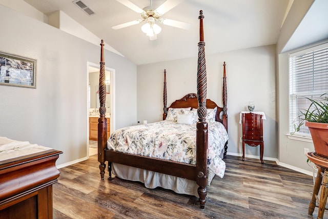 bedroom with baseboards, visible vents, vaulted ceiling, and wood finished floors