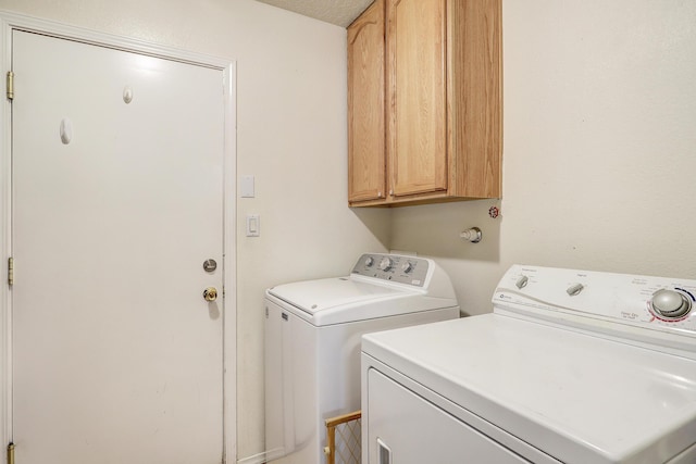 laundry area featuring washing machine and dryer and cabinet space