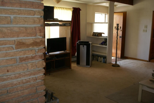 unfurnished living room with carpet floors, a baseboard radiator, and baseboards