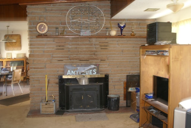 living area with a wood stove and tile patterned floors