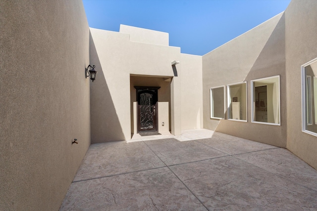 doorway to property featuring a patio and stucco siding