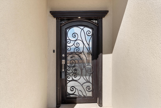 doorway to property featuring stucco siding