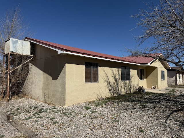 view of side of home with metal roof and stucco siding