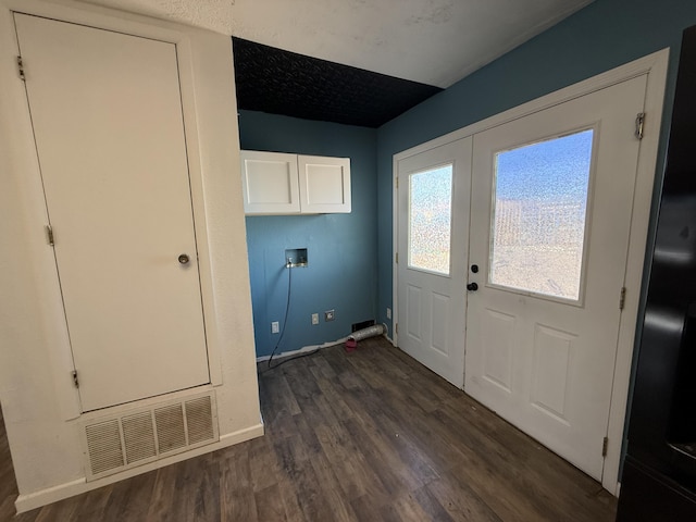 laundry area with french doors, dark wood finished floors, hookup for a washing machine, cabinet space, and visible vents