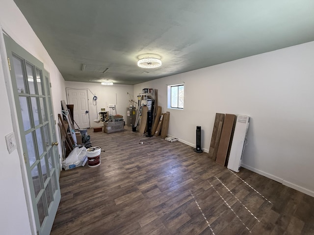 interior space with baseboards, dark wood-type flooring, and electric water heater