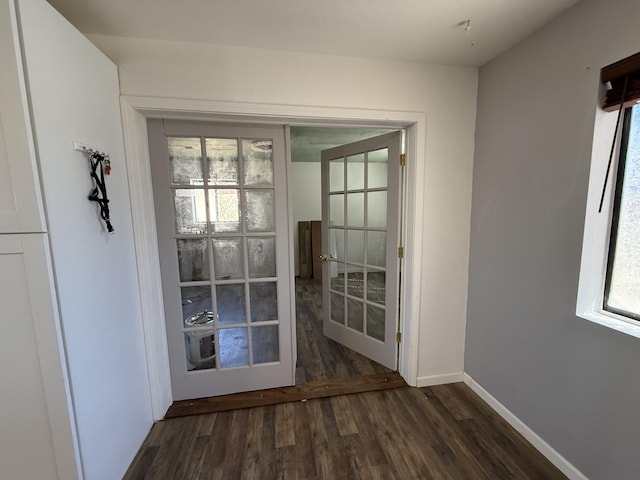 doorway featuring dark wood-style floors, baseboards, and french doors