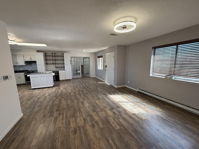 unfurnished living room featuring dark wood-type flooring, baseboard heating, visible vents, and baseboards