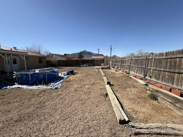 view of yard with a fenced backyard, a mountain view, and a fenced in pool