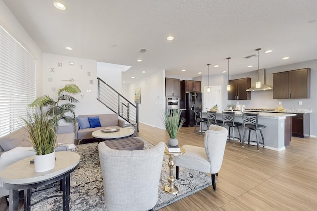 living room with stairway, recessed lighting, and visible vents