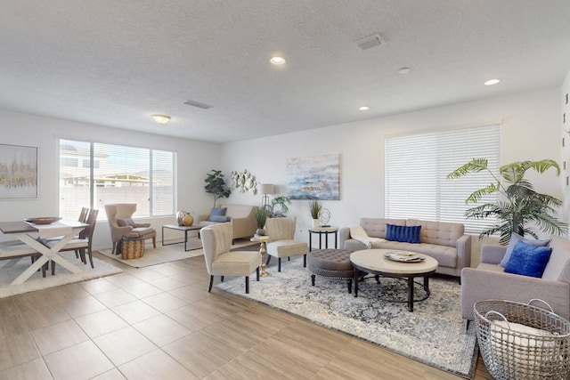 living room with visible vents, a textured ceiling, and recessed lighting