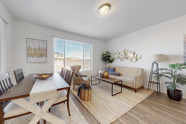 dining area featuring a textured ceiling and baseboards