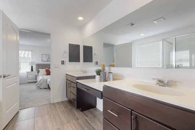 bathroom with visible vents, ensuite bathroom, a textured ceiling, vanity, and recessed lighting