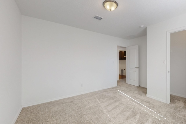 unfurnished bedroom featuring light carpet, visible vents, and baseboards