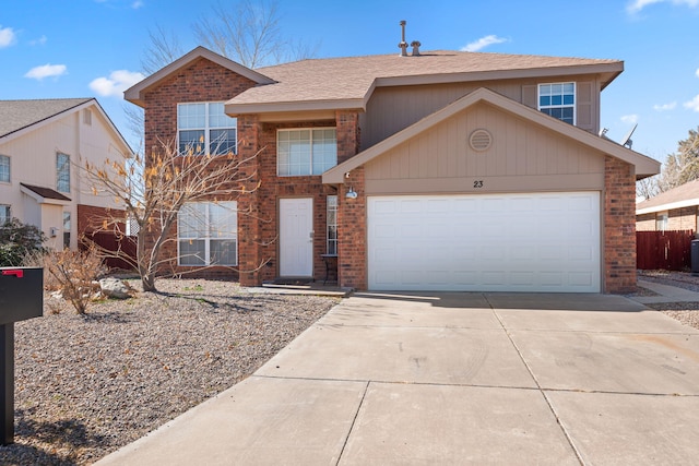 traditional-style home featuring a garage, driveway, and brick siding