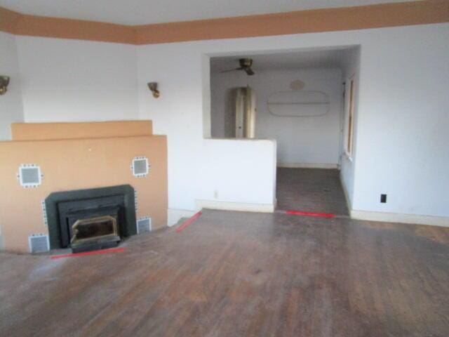 unfurnished living room with dark wood-style floors and a wood stove