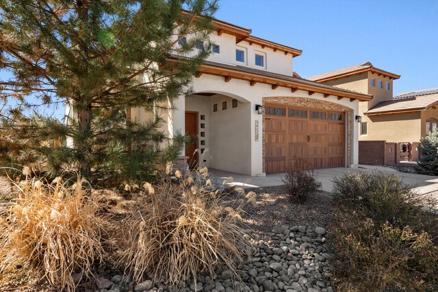 mediterranean / spanish-style home featuring concrete driveway and stucco siding