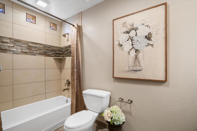 full bath featuring a textured ceiling, a textured wall, shower / bath combo with shower curtain, and toilet