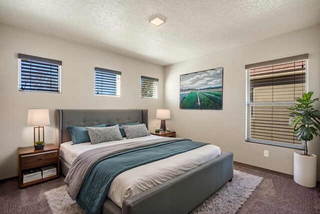 carpeted bedroom with baseboards and a textured ceiling