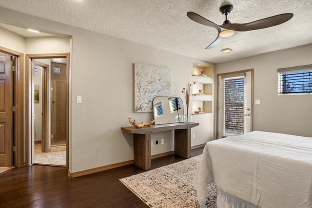 bedroom with a textured ceiling, ceiling fan, dark wood-style flooring, baseboards, and ensuite bath