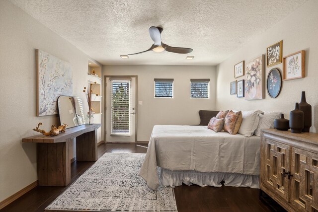 bedroom featuring access to exterior, dark wood-style flooring, ceiling fan, a textured ceiling, and baseboards