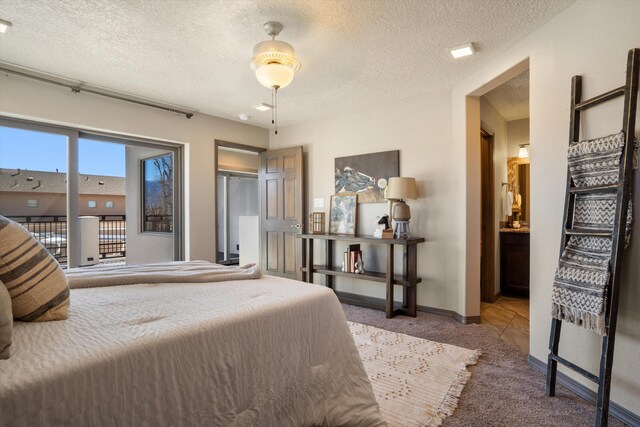 bedroom with a textured ceiling, carpet flooring, access to exterior, and baseboards