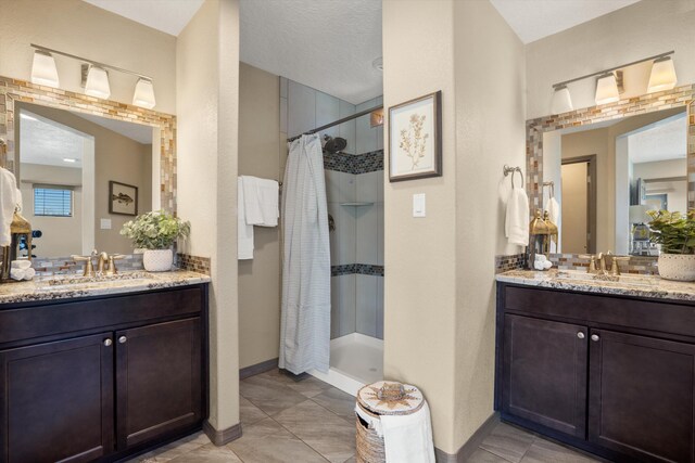 bathroom featuring a stall shower, two vanities, and a sink