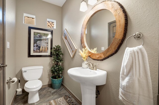 bathroom featuring baseboards and toilet