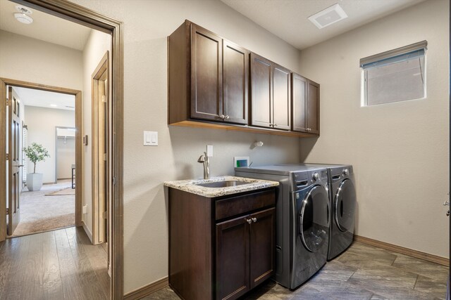 laundry room with washer and clothes dryer, visible vents, cabinet space, a sink, and baseboards