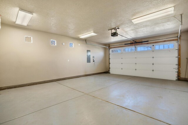 garage featuring electric panel, baseboards, and a garage door opener