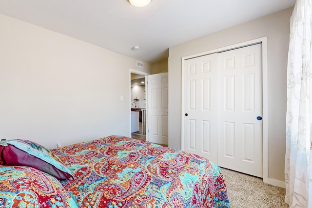 bedroom with a closet, light carpet, and visible vents