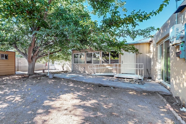 view of exterior entry with a patio area and fence