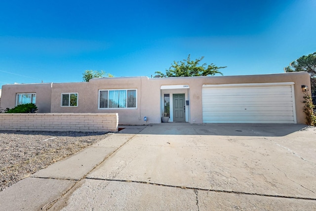 view of front of house with driveway, an attached garage, and stucco siding