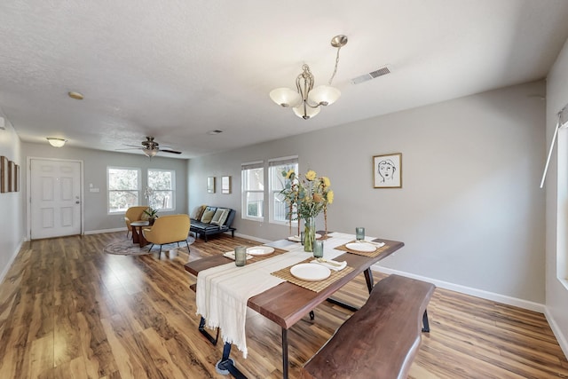 dining area with visible vents, baseboards, and wood finished floors