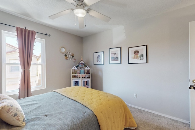 bedroom featuring baseboards, carpet, a ceiling fan, and a textured ceiling