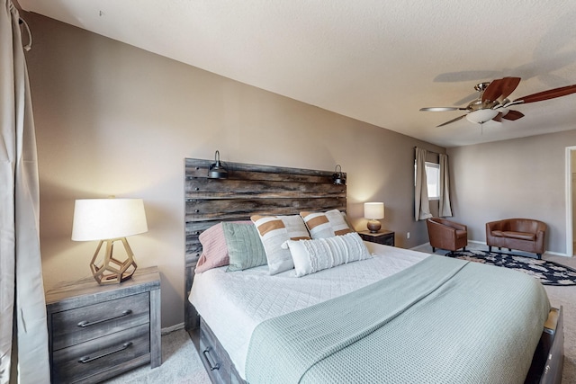 carpeted bedroom with ceiling fan and baseboards