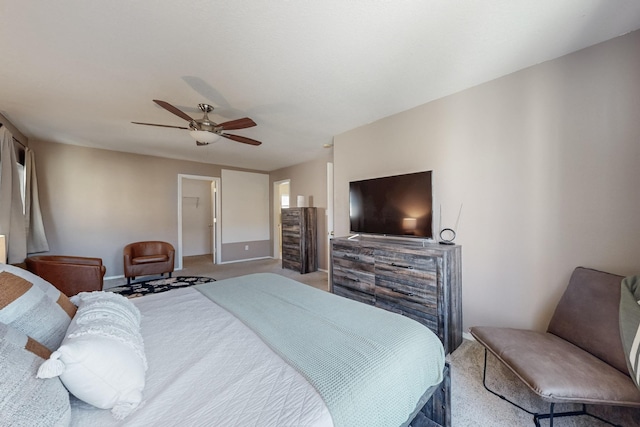 bedroom with carpet flooring, baseboards, a walk in closet, and a ceiling fan