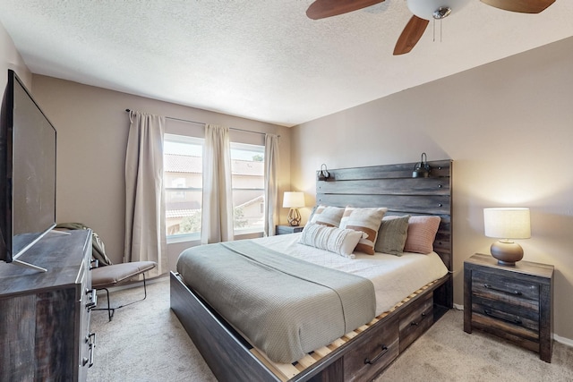 bedroom featuring a textured ceiling, light colored carpet, baseboards, and ceiling fan