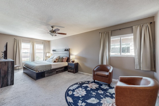 bedroom with carpet flooring, a textured ceiling, baseboards, and ceiling fan