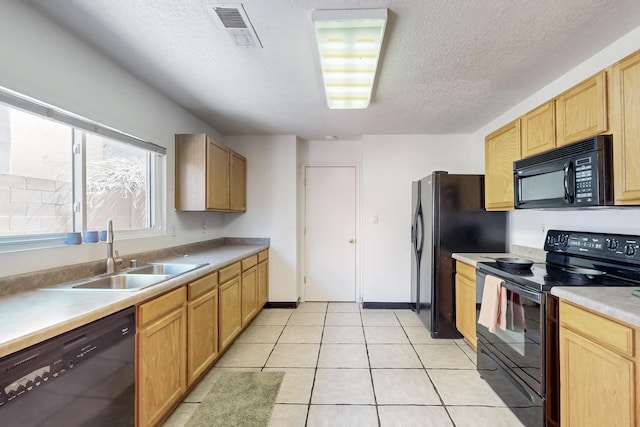 kitchen featuring light tile patterned floors, visible vents, a sink, black appliances, and a textured ceiling