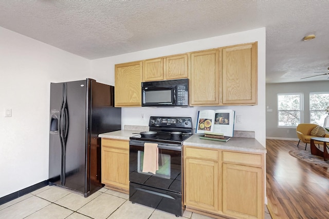 kitchen featuring a ceiling fan, black appliances, light countertops, and light brown cabinetry