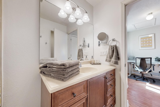 bathroom with vanity, an inviting chandelier, and wood finished floors