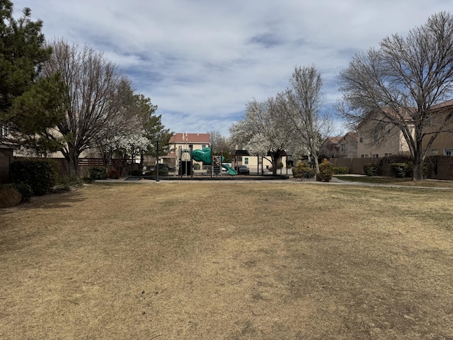 exterior space with playground community, a lawn, and fence