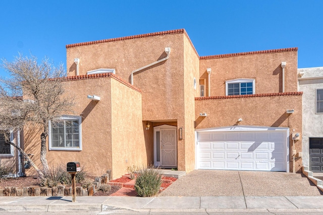 mediterranean / spanish home with concrete driveway, an attached garage, and stucco siding